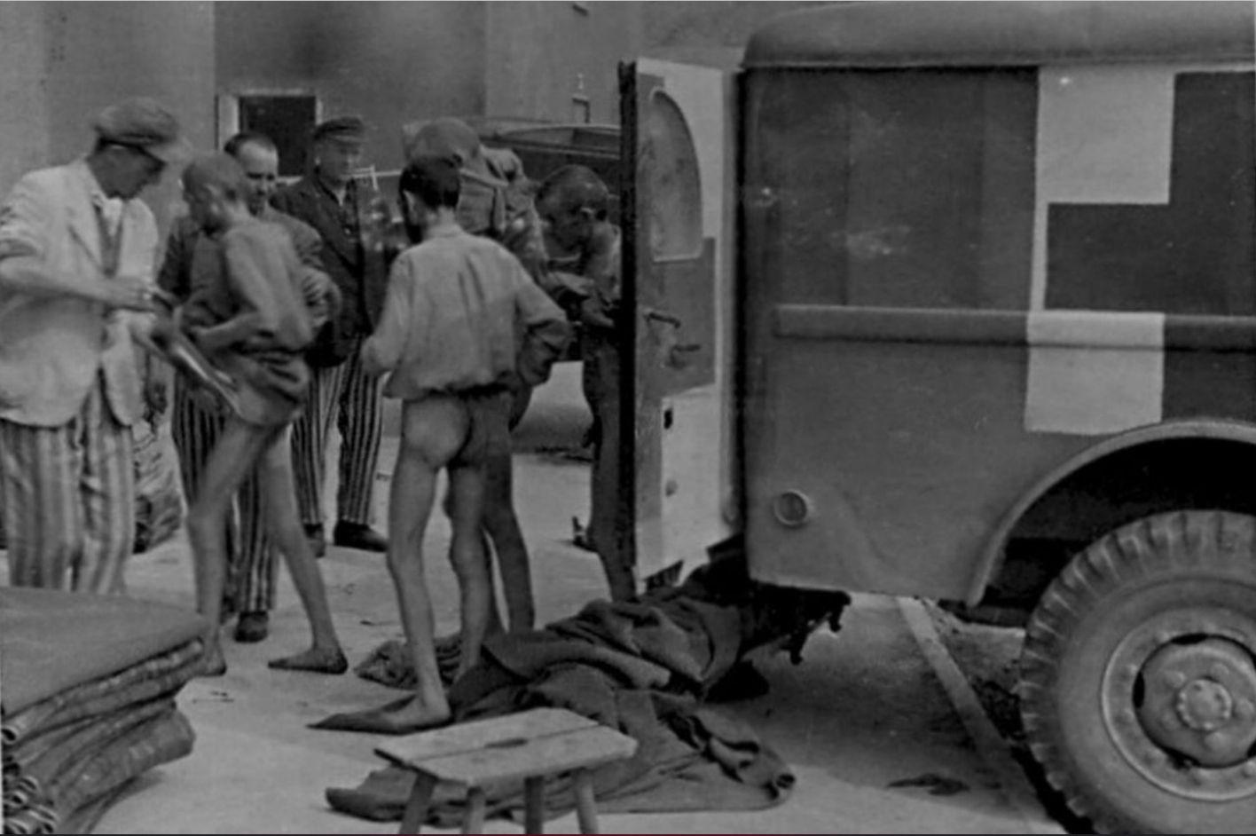 Two freed prisoners are examined in front of a military ambulance. 