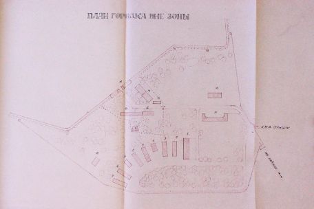 A plan of the preliminary zone of the special camp with a Cyrillic heading. At the bottom, the elongated, semicircular buildings of the former SS barracks can be seen, but only the scant half of them, resulting in approximately a quarter circle. Above are the functional buildings of the former commandant's office, the political department and the depot. The drawing still ends at the top with the camp fence and the gate building. Most of the buildings are numbered.