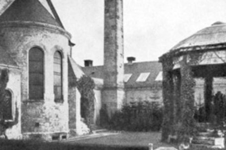 Hinter einer Kirche und einem Pavillon steht der Schornstein des Weimarer Krematoriums um 1928