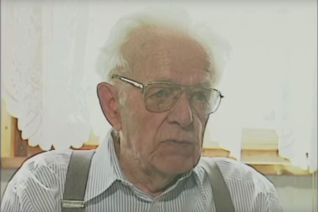 Screenshot from a video interview. An older man looks past the camera. 