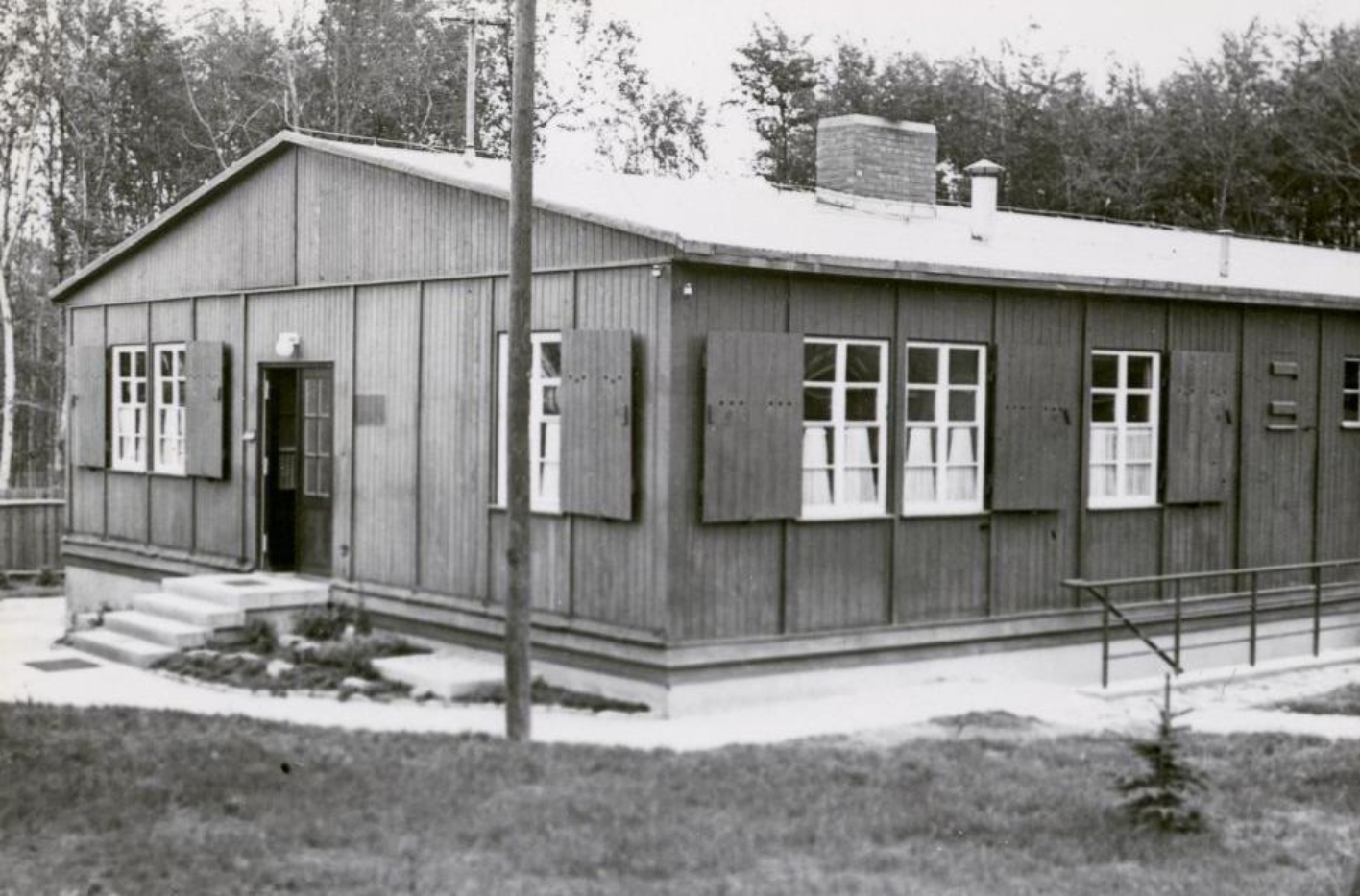 View of the so-called Sonderbau, a simple wooden barracks in which the SS had set up the camp brothel. From the inside, curtains are halfway up the windows. 