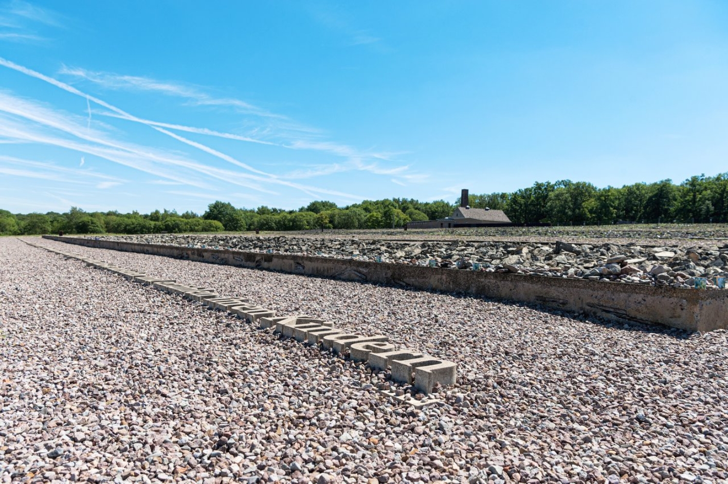 The inscription of the Jewish memorial on the ground: "That the future generation may know, the children that are born, that they may rise up and tell their children." Behind it the cinder stone field of the Jewish Memorial.