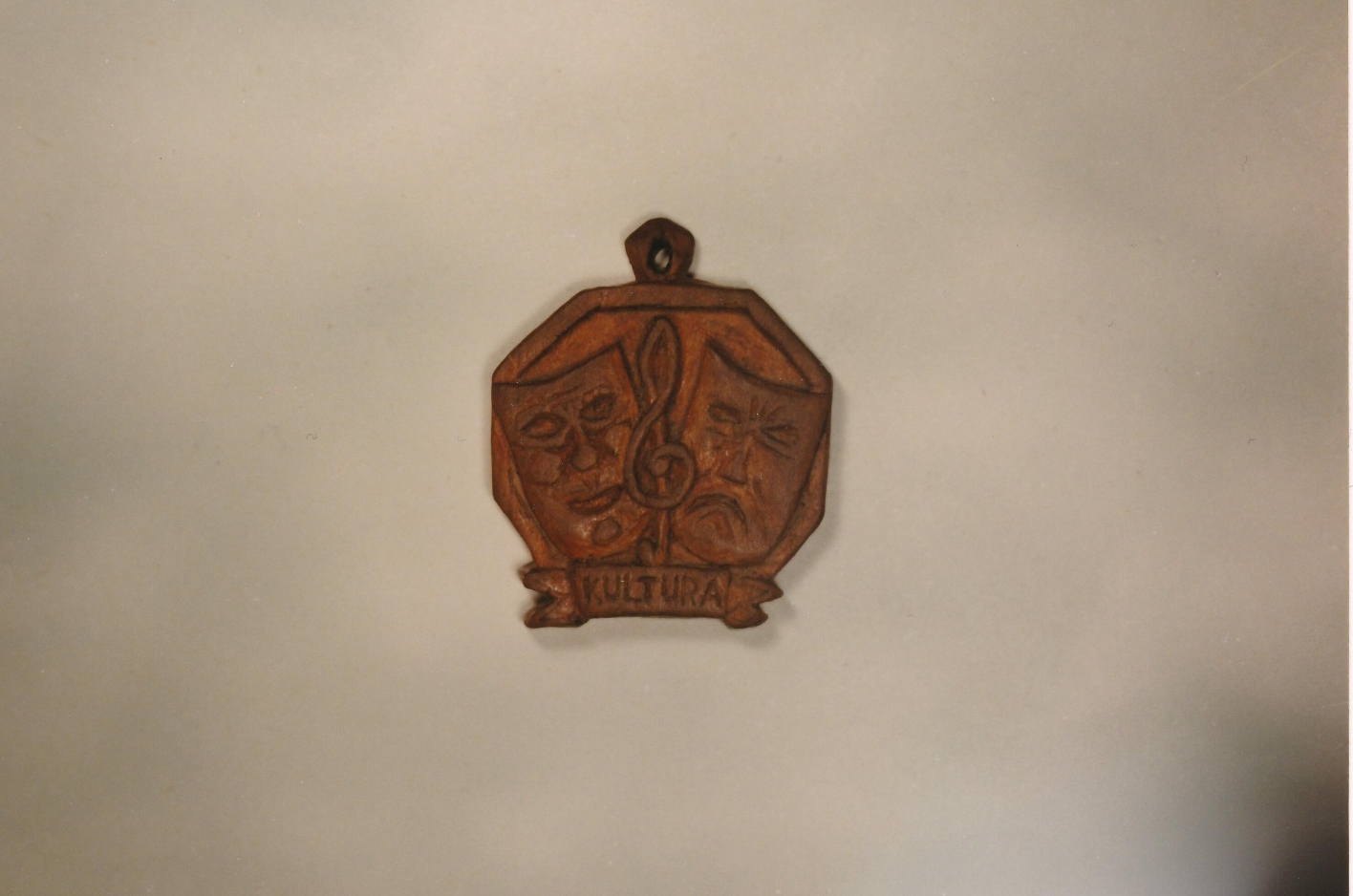 Wooden pendant from an in-house production of Goethe's Faust from 1946. The pendant is octagonal and shows a laughing and a sad mask next to each other.
