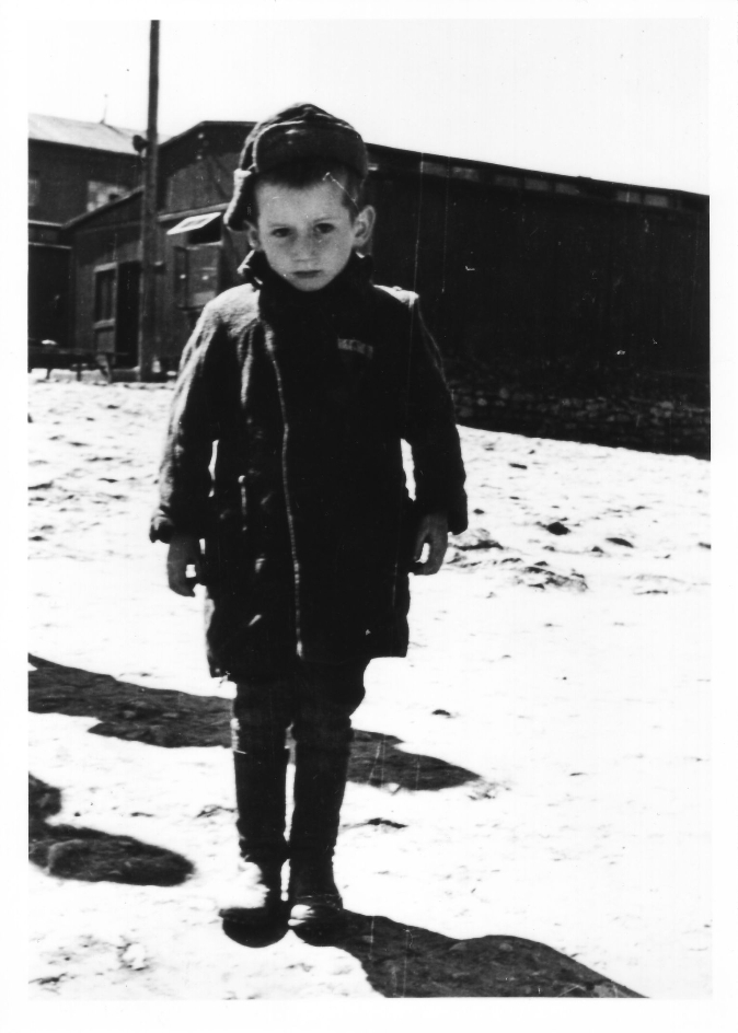  Stefan Jerzy Zweig, einer der jüngsten Überlebenden des Konzentrationslagers Buchenwald. Im Hintergrund sind links Block 47 und in der Mitte Block 59 zu erkennen.