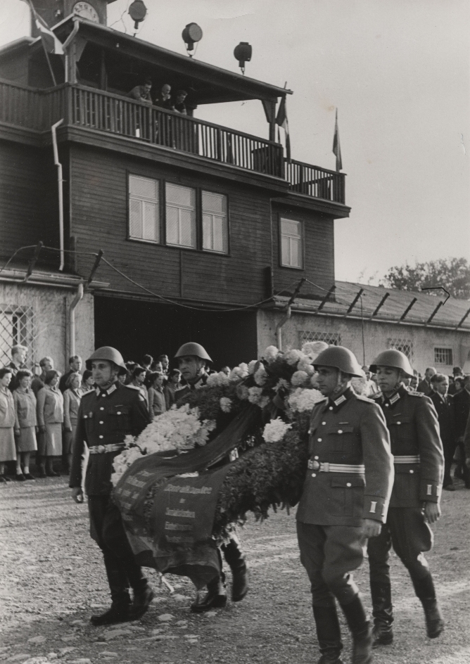 Inauguration ceremony of the Buchenwald National Memorial. Soldiers of the National People's Army of the GDR on the roll call square with a wreath from the Central Committee of the SED on the way to the Thälmann tribute in the inner courtyard of the crematorium. In the background the gate building.