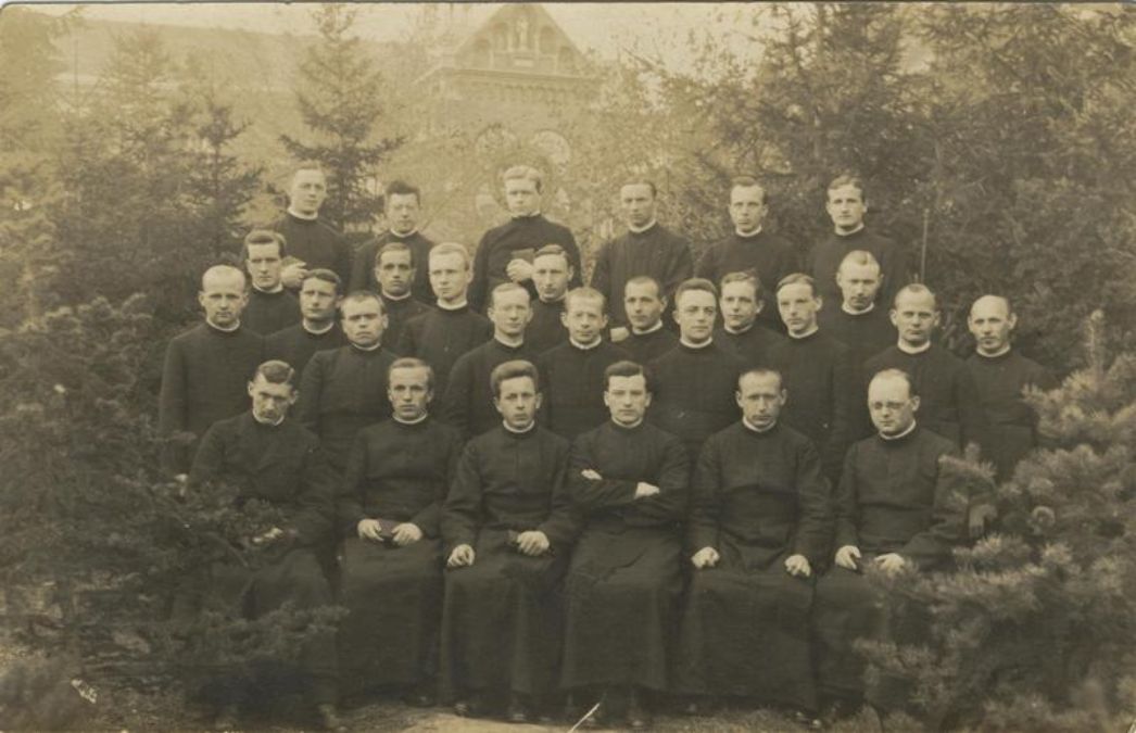 Gruppenaufnahme von 27 Männern in Priesterroben