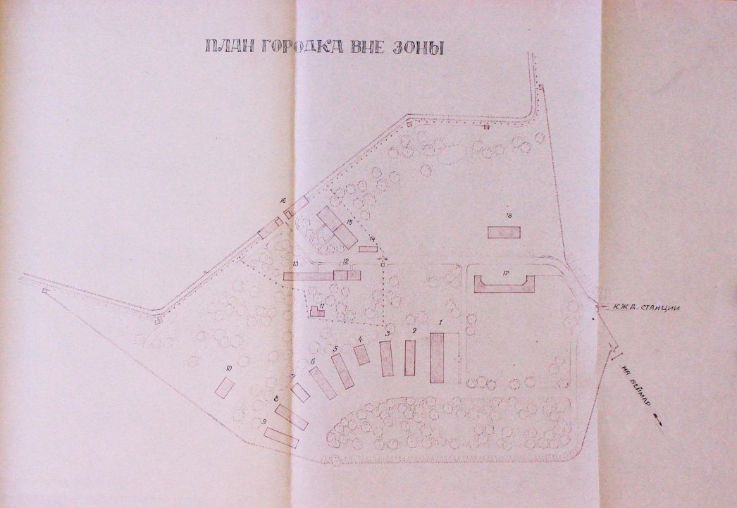 A plan of the preliminary zone of the special camp with a Cyrillic heading. At the bottom, the elongated, semicircular buildings of the former SS barracks can be seen, but only the scant half of them, resulting in approximately a quarter circle. Above are the functional buildings of the former commandant's office, the political department and the depot. The drawing still ends at the top with the camp fence and the gate building. Most of the buildings are numbered.