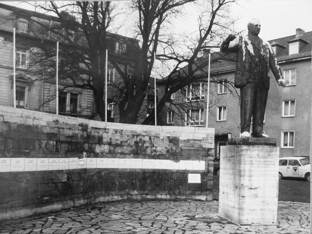 Das vernachlässigte Ernst-Thälmann-Denkmal, hinter der Statue erinnern Klebezettel an die Opfer rechtsradikaler Gewalt