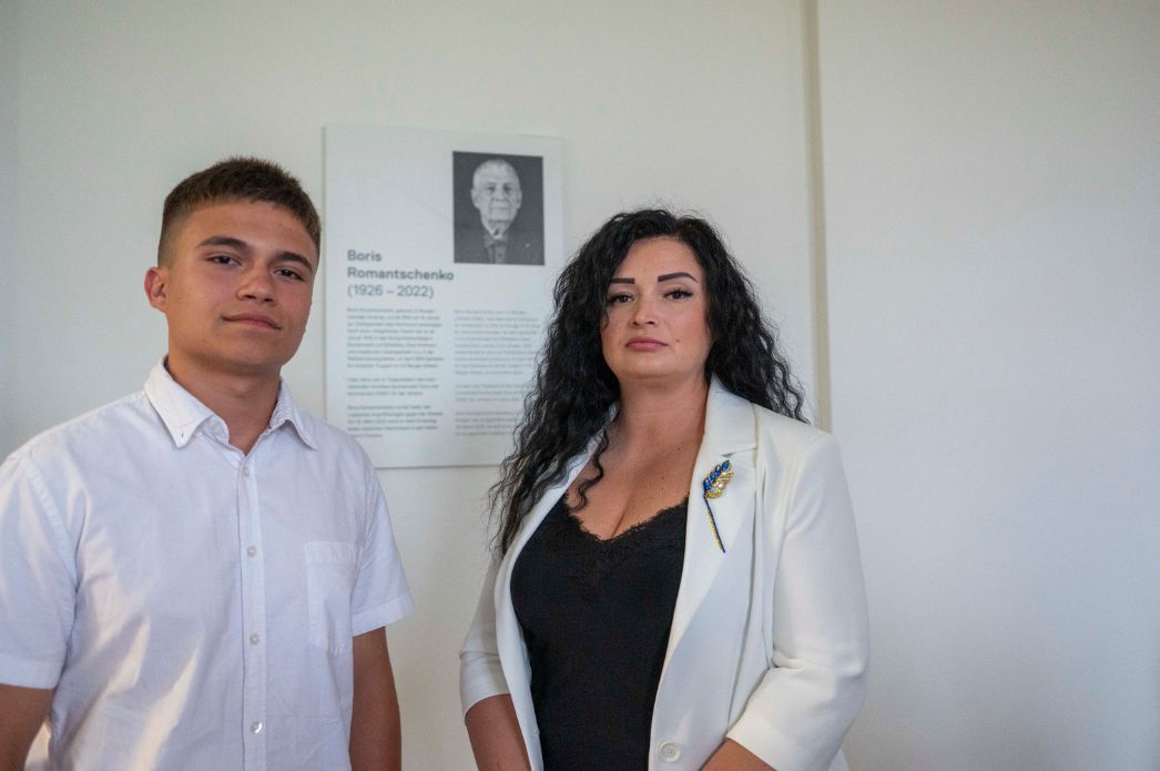 Julia Romantschenko und Ihr Sohn Kyryl vor der Namenstafel des Saals