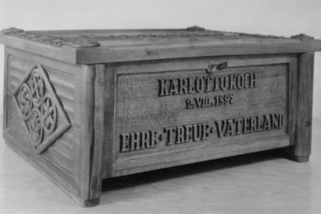 Eine geschnitzt verzierte Holztruhe mit der Aufschrift "Karl Otto Koch, 2.8.1897 Ehre Treue Vaterland".