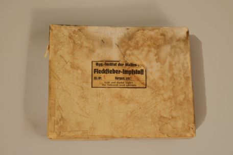 Ein vergilbtes Paket mit der Aufschrift "Hygienisches Institut der Waffen-SS - Fleckfieber Impfstoff"