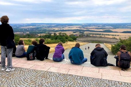 Gruppe sitzt auf den Stufen der Mahnmalsanlage.