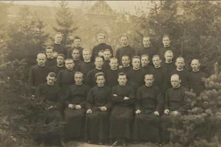 Group shot of 27 men in priest robes