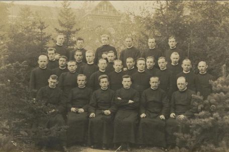 Group shot of 27 men in priest robes
