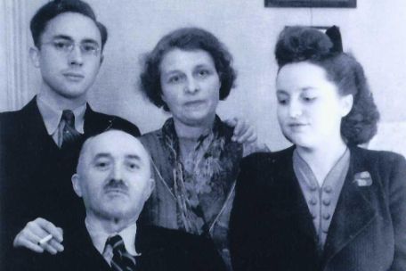 Group shot of Jacqueline Marié. To her right are her mother and brother, in front of them sits her father at a desk