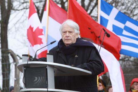 Jorge Semprún standing at the lectern with country flags behind him.