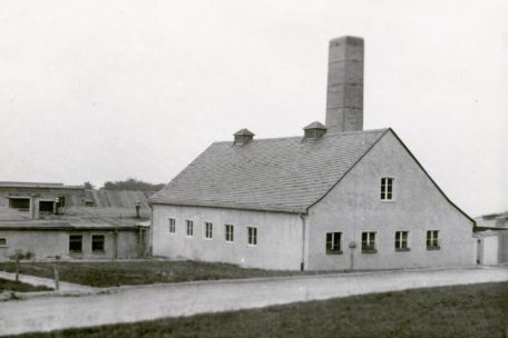  Das Krematoriumsgebäude von außen. Im Zentrum des Bildes ragt der Ziegelsteinschornstein auf.