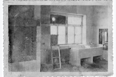Verwittertes Foto eines Waschraums. Zwei tiefe Waschbecken in einem gefließten Raum. 