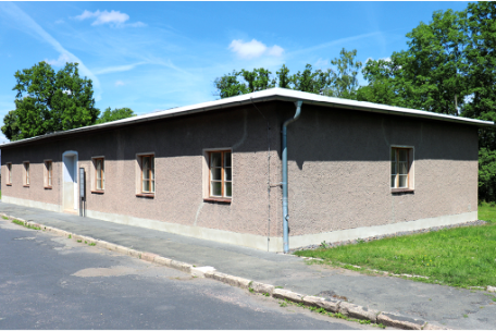 A flat, one-story building with a plain facade on the edge of the street.