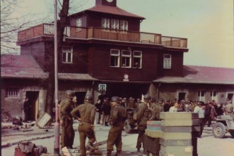 US-Soldaten vor dem Lagertor. Rechts im Vordergrund sind Munitionskisten der SS zu sehen. 