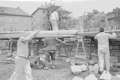 Zusehen sind Bauarbeiter. Links trägt ein Mann Holzlatten von Links nach Rechts. Rechts ist ein Maurer zu Gange. Auf einer Mauer Steht ein weiterer Arbeiter in der Mitte des Bildes. Im Hintergrund sieht man eingerüstete Gebäude.