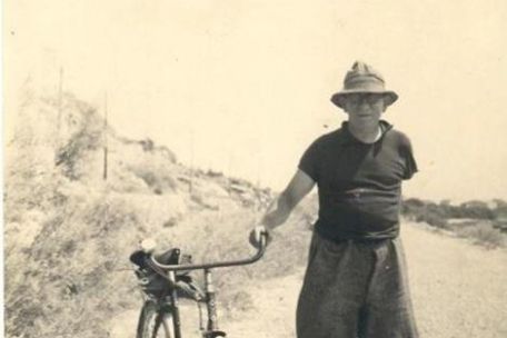 André Bach an einer Landstraße mit einem Fahrrad. 