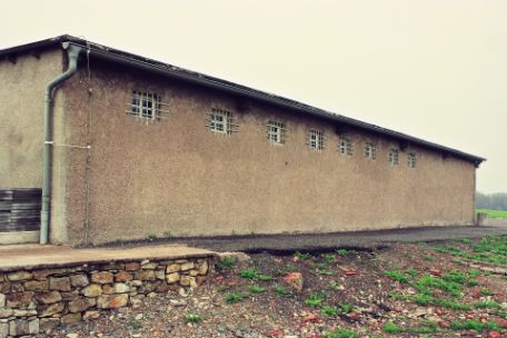 Außenansicht des "Bunkers" im Anbau des Krematoriums. Unterhalb des Dachs sind sieben kleine vergitterte Fenster zu erkennen.