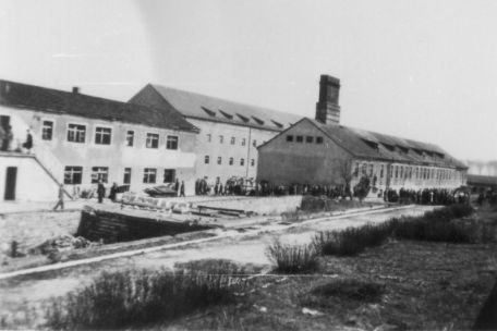  Blick aus nordwestlicher Richtung auf die Steinbaracke Nr. 13 und das dahinterliegende Kammergebäude. Ganz rechts die ehemalige Häftlingswäscherei.