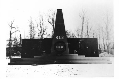 Ein hölzerner Obelisk auf einem hölzernen Podest. Er trägt die Aufschrifft "K.L.B - 51.000".