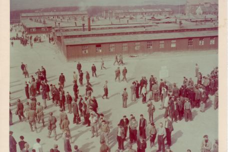 Blick vom Torgebäude über das Lager. Auf dem Appellplatz stehen befreite Häftlinge und US-Soldaten. Ganz rechts im Hintergrund das Kammergebäude.