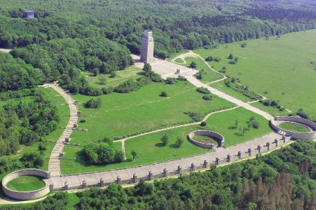 Das Mahnmal auf dem Gelände der Gedenkstätte aus der Luft fotografiert. Links oben beginnt der Stelenweg bergab. Weiter unten führt die Straße der Nationen von einem Ringgrab zum nächsten. Auf halber Strecke sieht man noch ein weiteres Ringgrab. Von dort führt der Weg bergauf zum Glockenturm.