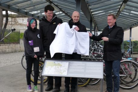 Eine Frau und drei Männer, darunter Heiko Clajus, am Hauptbahnhof, die Gedenktafel enthüllend.