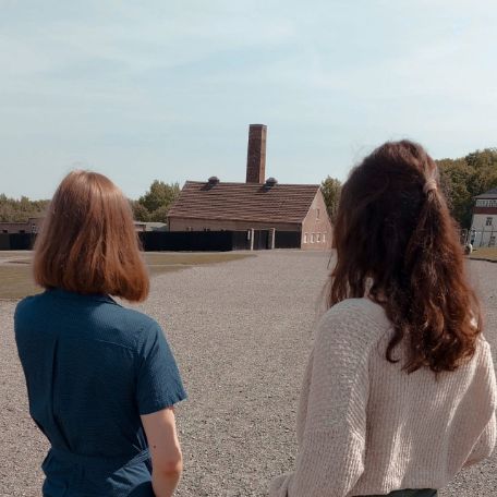 Zwei Freiwillige blicken über den ehemaligen Appellplatz in der Gedenkstätte Buchenwald