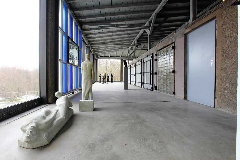 View into the glazed area of the art exhibition where sculptures are placed.