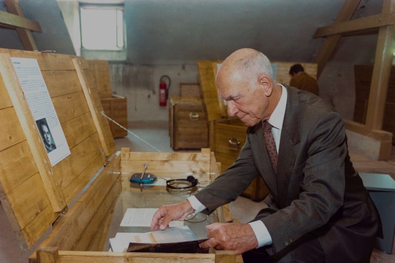 Das Foto zeigt Stéphane Hessel in der Hocke vor einer aufgeklappten Kiste.
