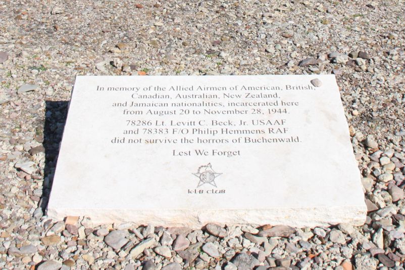 Heller Gedenkstein in einem Schotterbeet. Mit der Gravur: "In memory of the Allied Airmen of America, British, Canadian, Australian, New Zealand, and Jamaican nationalties, incarcerated here from August 20 to November 28, 1944. 78286 Lt. Levitt C. Beck, Jr. USAAF and 78383 F/O Philip Hemmes RAF did not survive the horrors of Buchenwald. Lest we forget." 