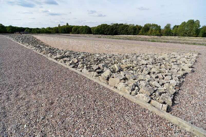 Eine lange rechteckige Fläche, die mit Bruchsteinen gefüllt ist. Zur Mitte befinden sich weniger Steine, weshalb eine Senke zu erkennen ist.