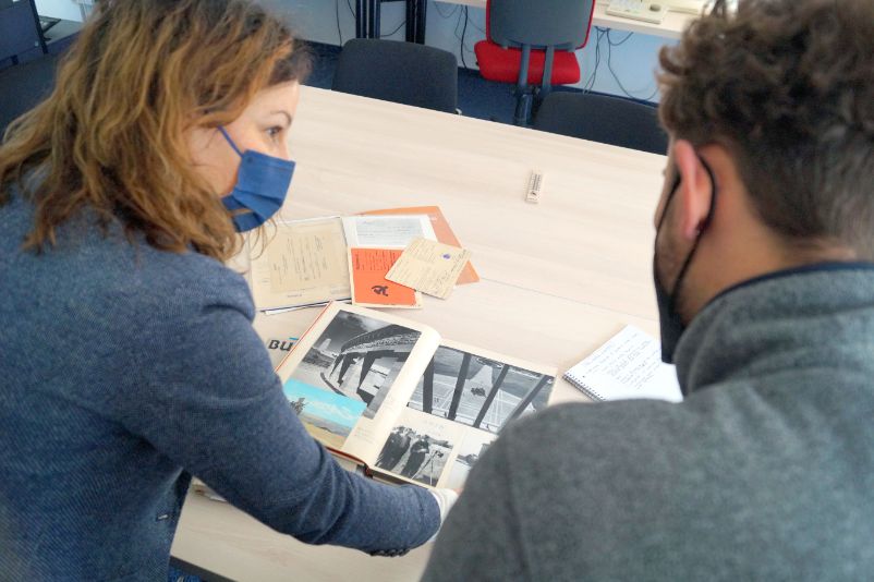 Two employees at a table looking at photos. 