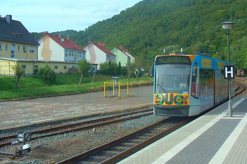 Eine Straßenbahn an einem Bahnsteig. Auf der Anzeige über der Frontscheine steht" 10, Ilfeld/Neanderklinik. 